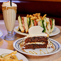 A milkshake, a sandwich and fries, and cake