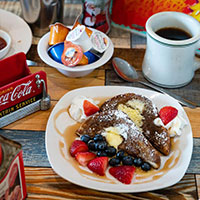 French toast with whipped cream and fruit and coffee