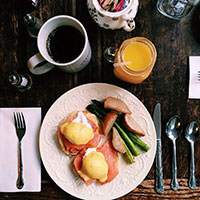 Tea, orange juice, and breakfast food on a table