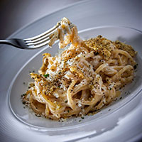 Pasta in a bowl with fork digging in.