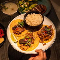 A plate with three tacos and rice