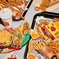 Multiple fries, onion rings, dipping sauces, and burgers