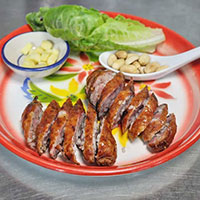 A plate with steak cut up and lettuce